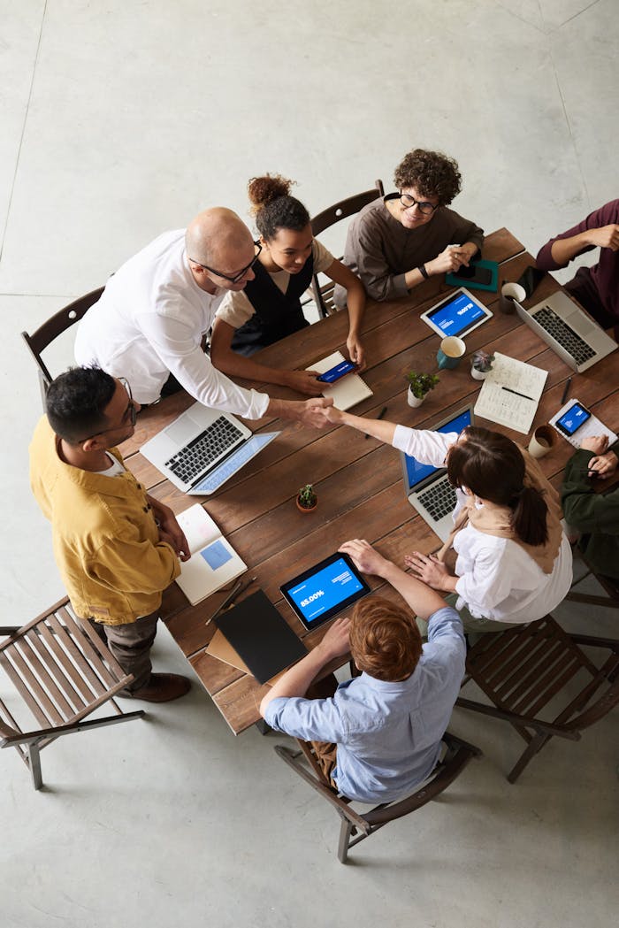 about-bg Overhead shot of a diverse team collaborating in a modern office meeting.