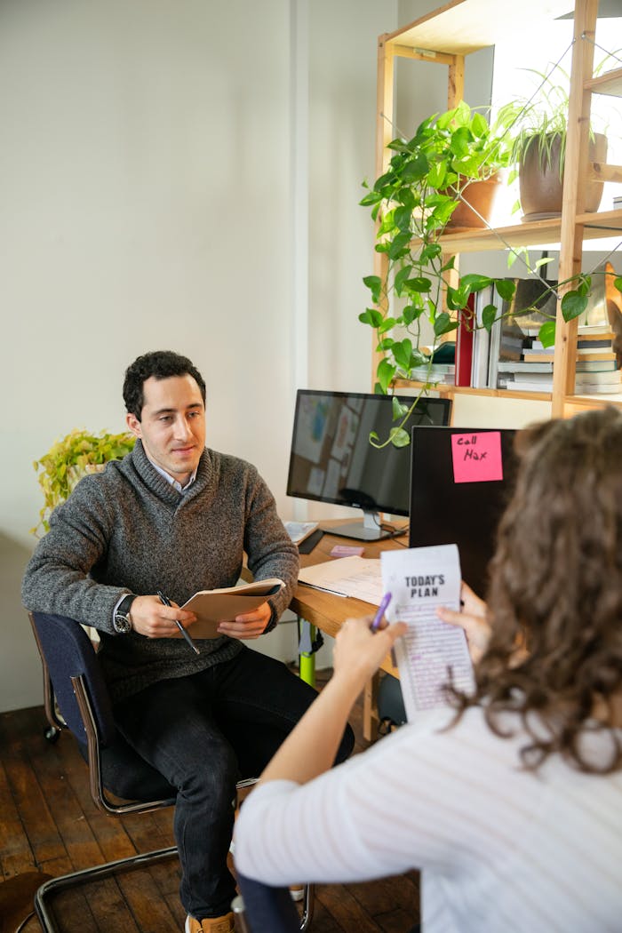 our-story Two colleagues discussing business plans at a modern office desk.
